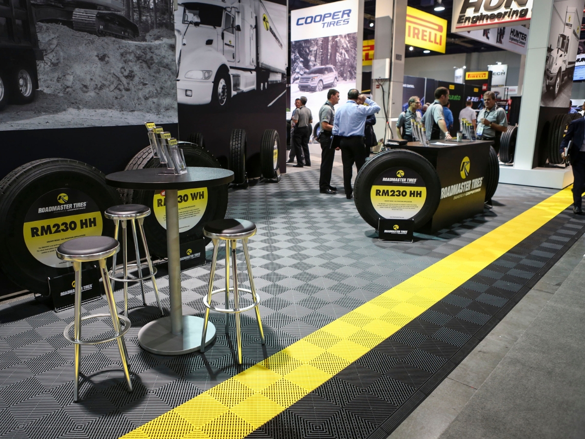 Anwendungsbeispiel: Messestand mit grauem Ribtrax Pro Gitterboden und gelbem Farbstreifen
